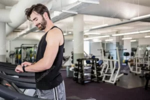 men in black shirt looking at his smartwatch in the gym